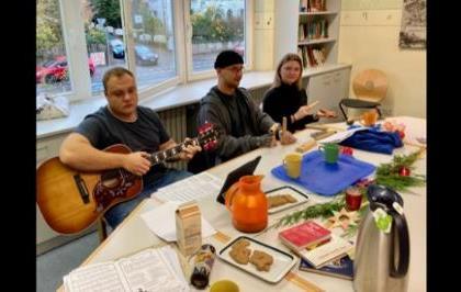 Schüler:innen im Unterricht. Einer hat eine Gitarre.