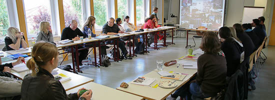 Scüler:innen im Klassenraum mit Beamerleinwand